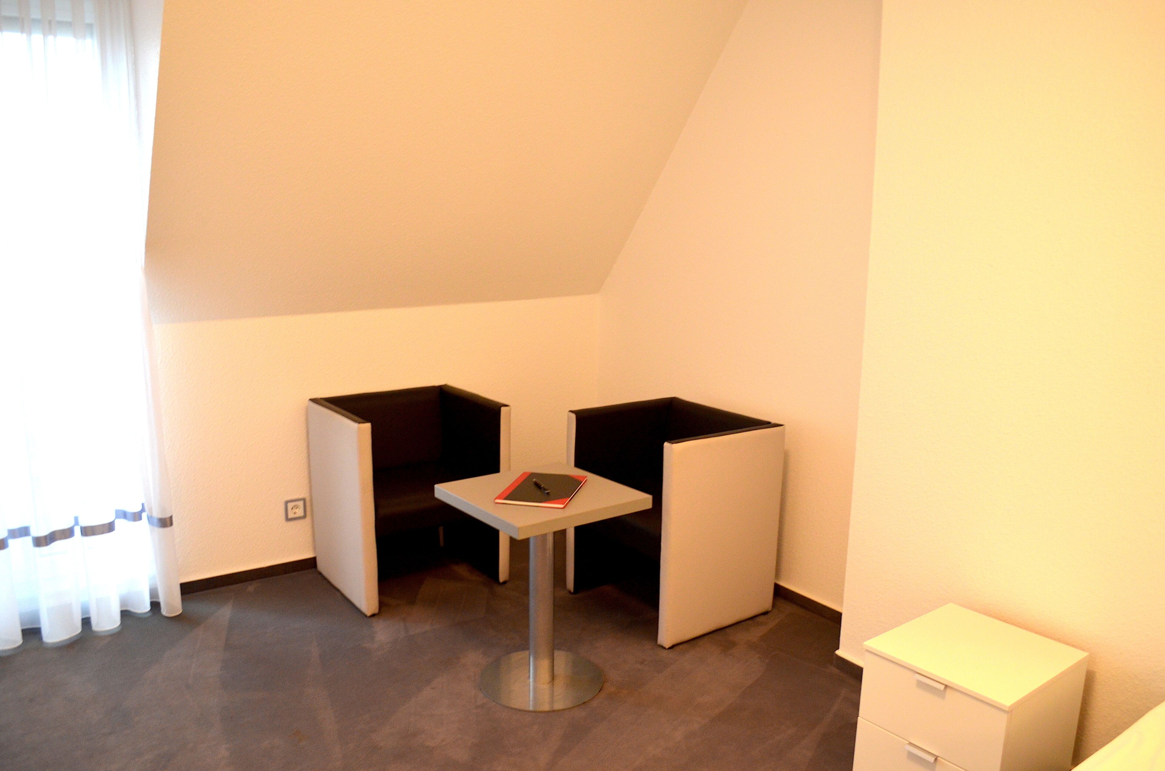 A small, modern room with a single table and two chairs.