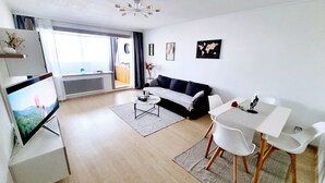 Un salon moderne avec un canapé, une table basse et un coin repas.