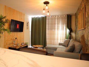 Relax in this stylish living room with a flat-screen TV, comfortable sofa, and floor lamp.