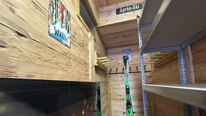 A wooden interior with a ski rack, a sign reading "Wallis," and a shelf unit. - Ferienhaus Lomatte 1758 by Interhome (Saas-Fee)