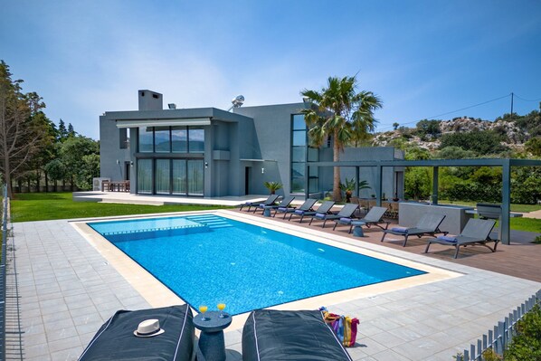 Relax by the rectangular pool surrounded by a tiled deck and lounge chairs.