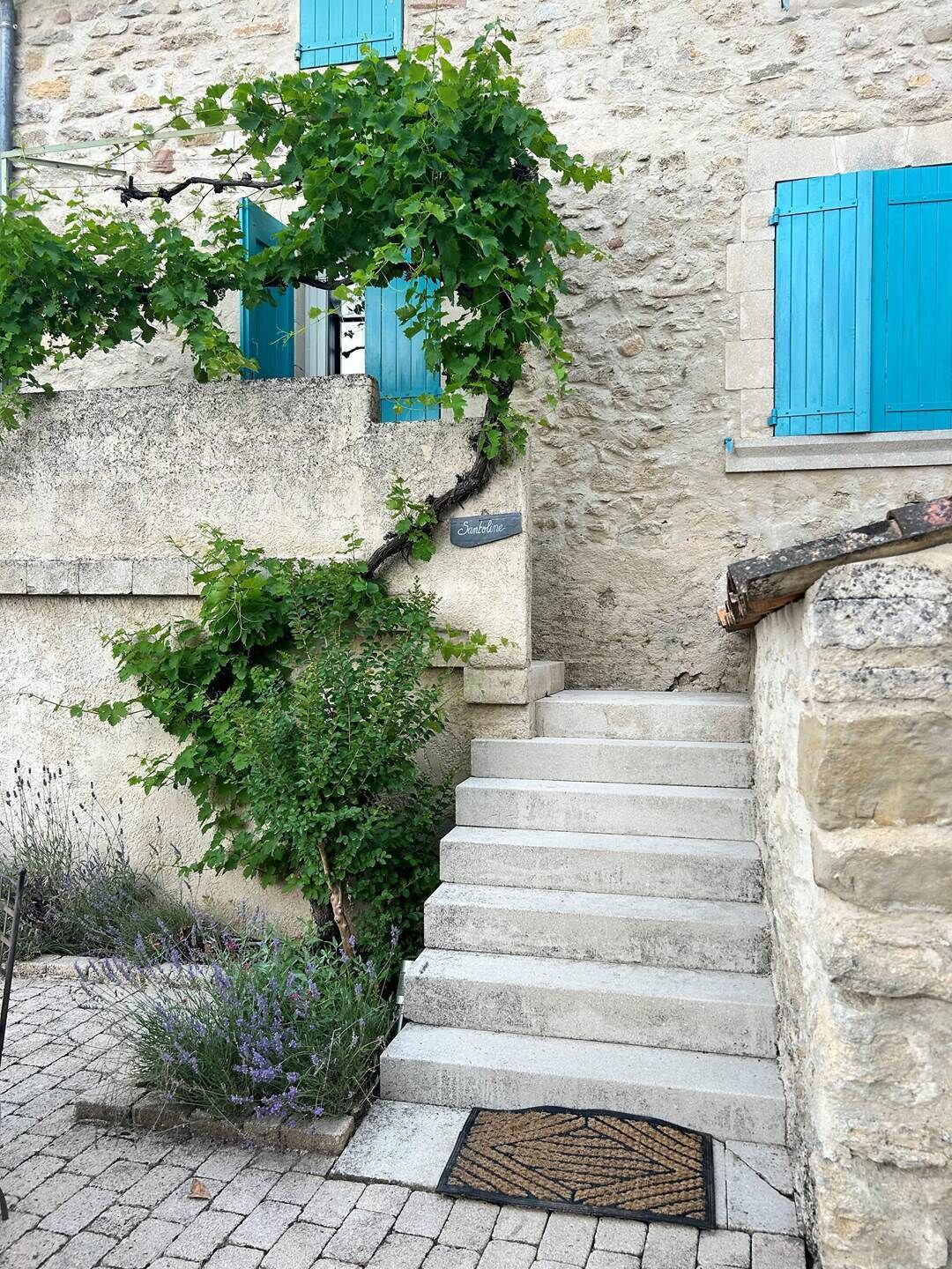 A stone staircase leading to a building with a sign reading 'Santolina.'