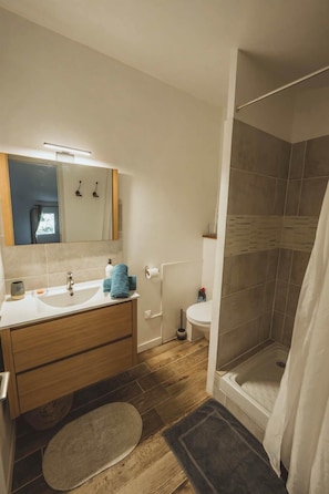 A bathroom with a sink, mirror, towel, toilet, and shower. - Santoline Holiday Cottage (Niozelles)