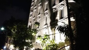 A multi-story building with illuminated windows and a gated entrance. - Chez Moi Bangkok Sukhumvit 26 Executive Residence (888) (Klong Toey)