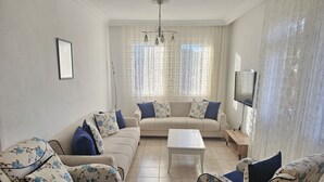 A living room with a sofa set, a coffee table, and a TV. - Azure Ev Fethiye (Fethiye)