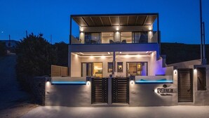A modern two-story house with a swimming pool, a covered patio, and a gated entrance. - Blue Pearl Suite in Tinos  (Tinos Town)