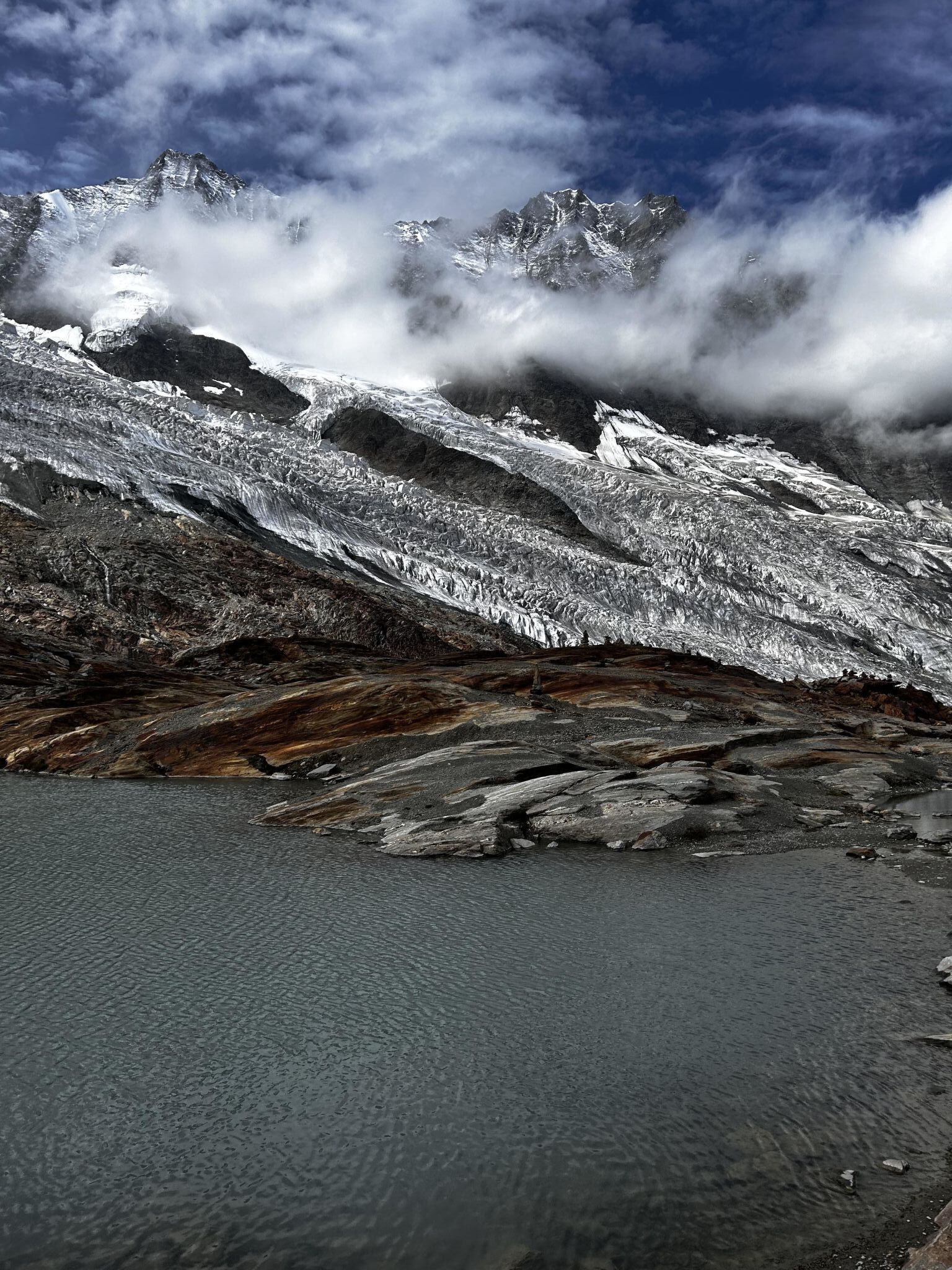 Paesaggio montuoso con un ghiacciaio e un corpo d'acqua.