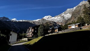 A mountain resort with snow-capped peaks, a clear sky, and a mix of modern and traditional buildings. - Evelyne by Interhome (Saas-Fee)