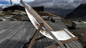 A wooden deck with a hammock and picnic table, overlooking a mountainous landscape with a cloudy sky. - Evelyne by Interhome (Saas-Fee)