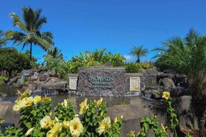 A sign for The Westin Princeville, surrounded by tropical vegetation and a small waterfall.