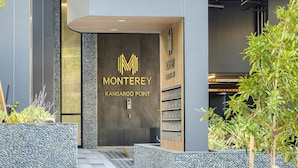 The entrance to a modern building with a sign reading "9 Lambert" and "Monterey Kangaroo Point." - The Monterey Apartments by Urban Rest (Kangaroo Point)