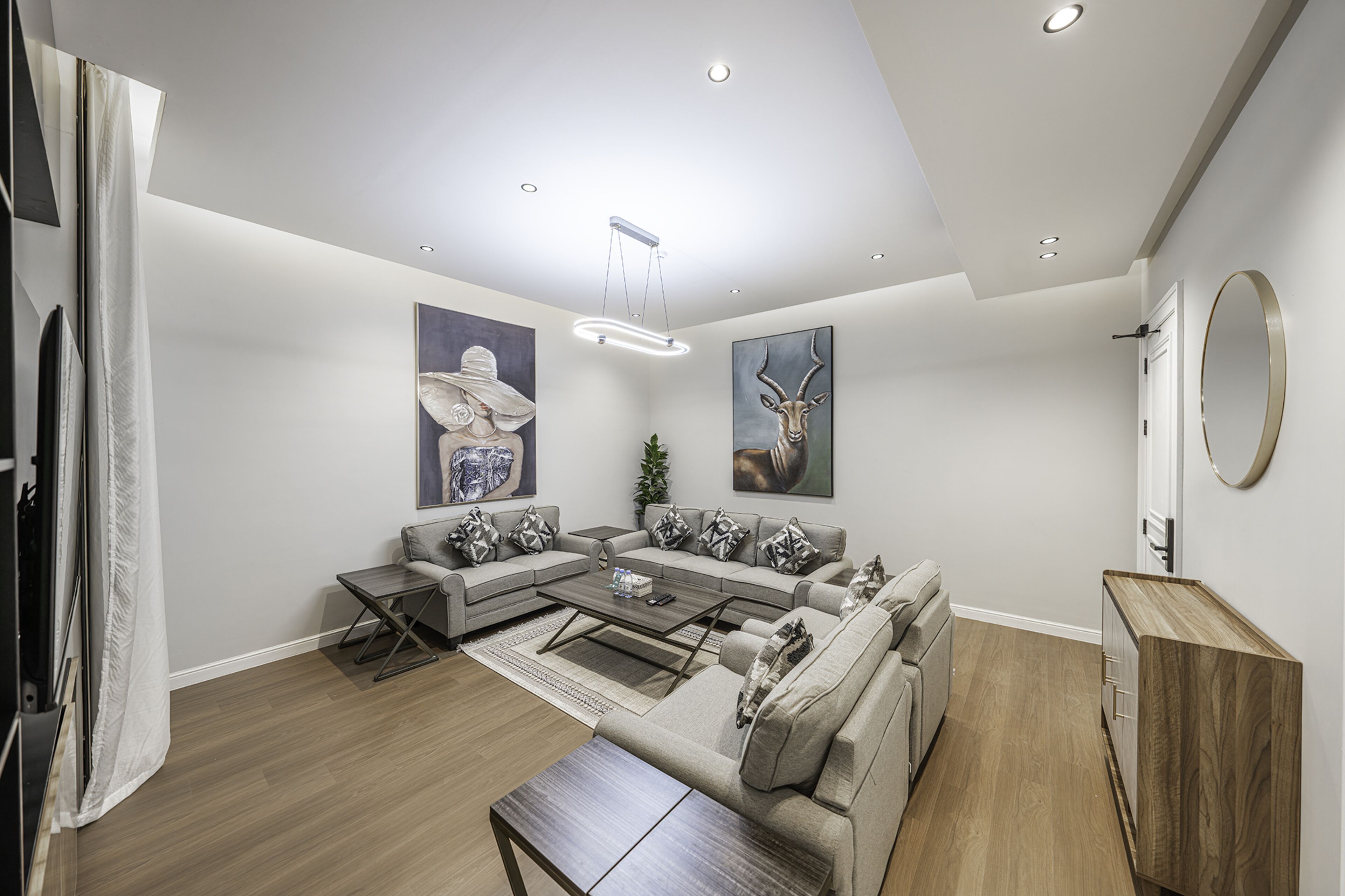 A modern living room with a sectional sofa, a coffee table, and a wooden cabinet.