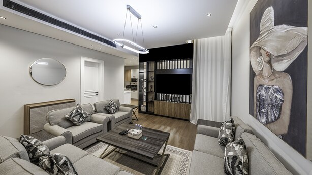 A modern living room with a sofa set, a coffee table, and a painting on the wall. - Mabaat - Al Malqa - 543 (Riyadh)