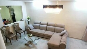 A living room with a sectional sofa, a coffee table, and a dining area with chairs. - Villa Des Quatre Saisons (Pereybere)