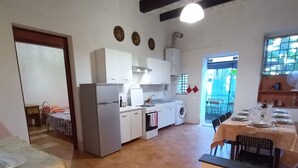 A compact kitchen with white cabinets, a refrigerator, a washing machine, and a dining area with a table set for four. - Sosia Palace, Pisa (Pisa)