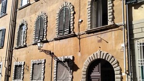 A building with multiple arched windows and a central door, featuring stone detailing and a yellow facade. - Sosia Palace, Pisa (Pisa)