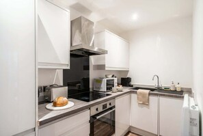 Una cocina moderna con horno empotrado, microondas y tostadora.