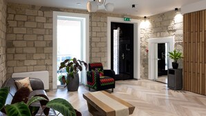A modern interior with a brick wall, a wooden bench, a sofa, and a potted plant. - ECODOR HOTEL (Orhei)