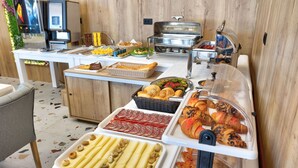 En buffet med et udvalg af mad, herunder kød, oste og bagværk.