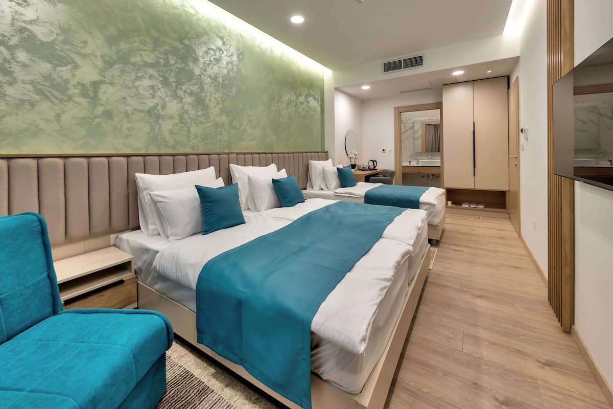 A modern hotel room with a large bed, a desk, a chair, and a bathroom.