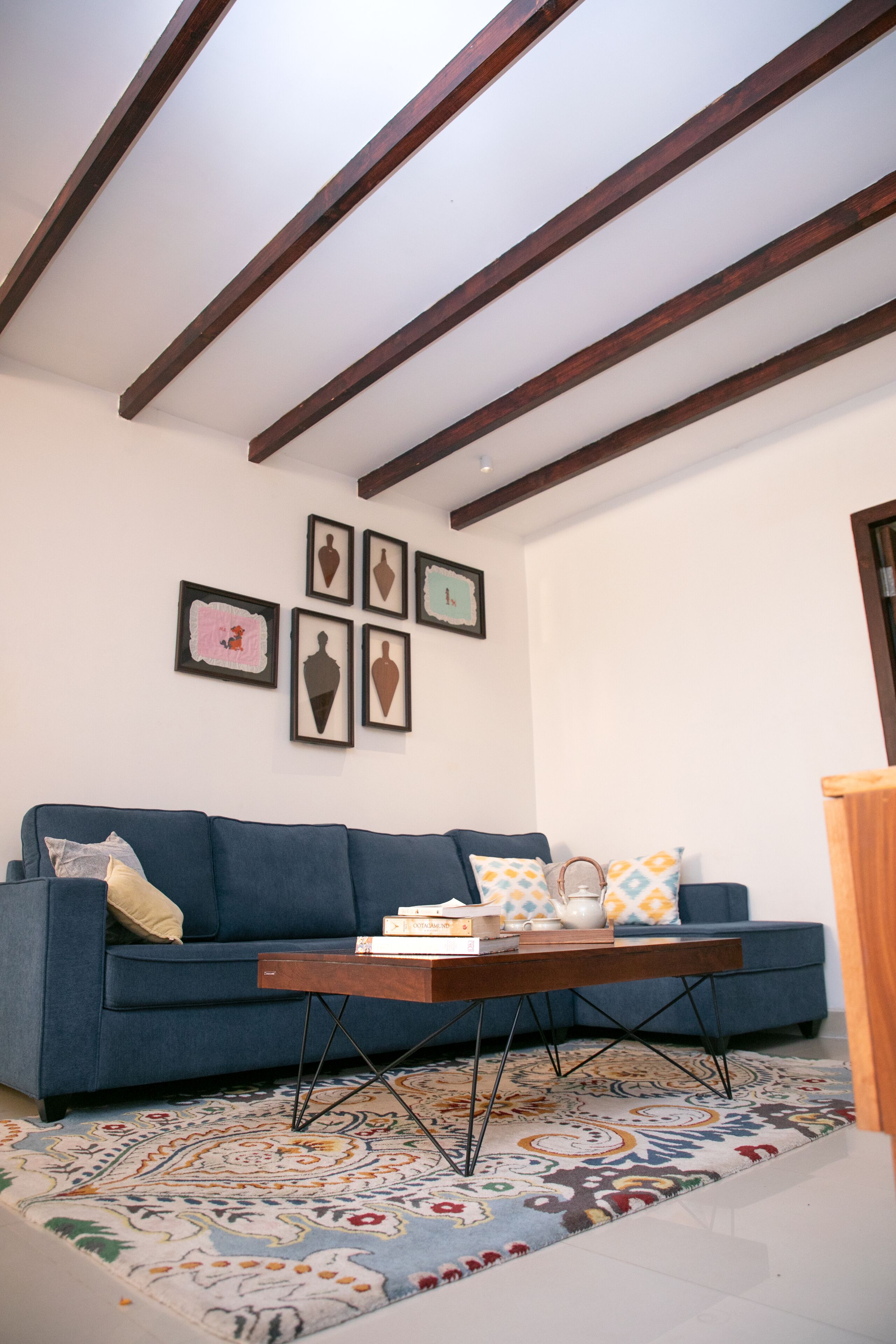 A living room with a blue sofa, a coffee table, and a patterned rug.