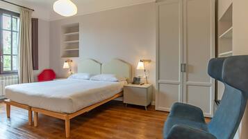Ein Schlafzimmer mit einem Bett, Nachttischen, einem Sessel und einem Kleiderschrank.
