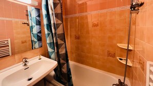 Ein Badezimmer mit Waschbecken, Dusche und gefliesten Wänden.