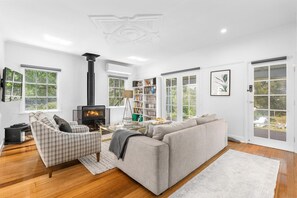 A modern living room with a fireplace, sofa, and bookshelf.