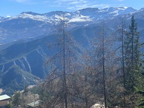 Eine Berglandschaft mit schneebedeckten Gipfeln und blauem Himmel.
