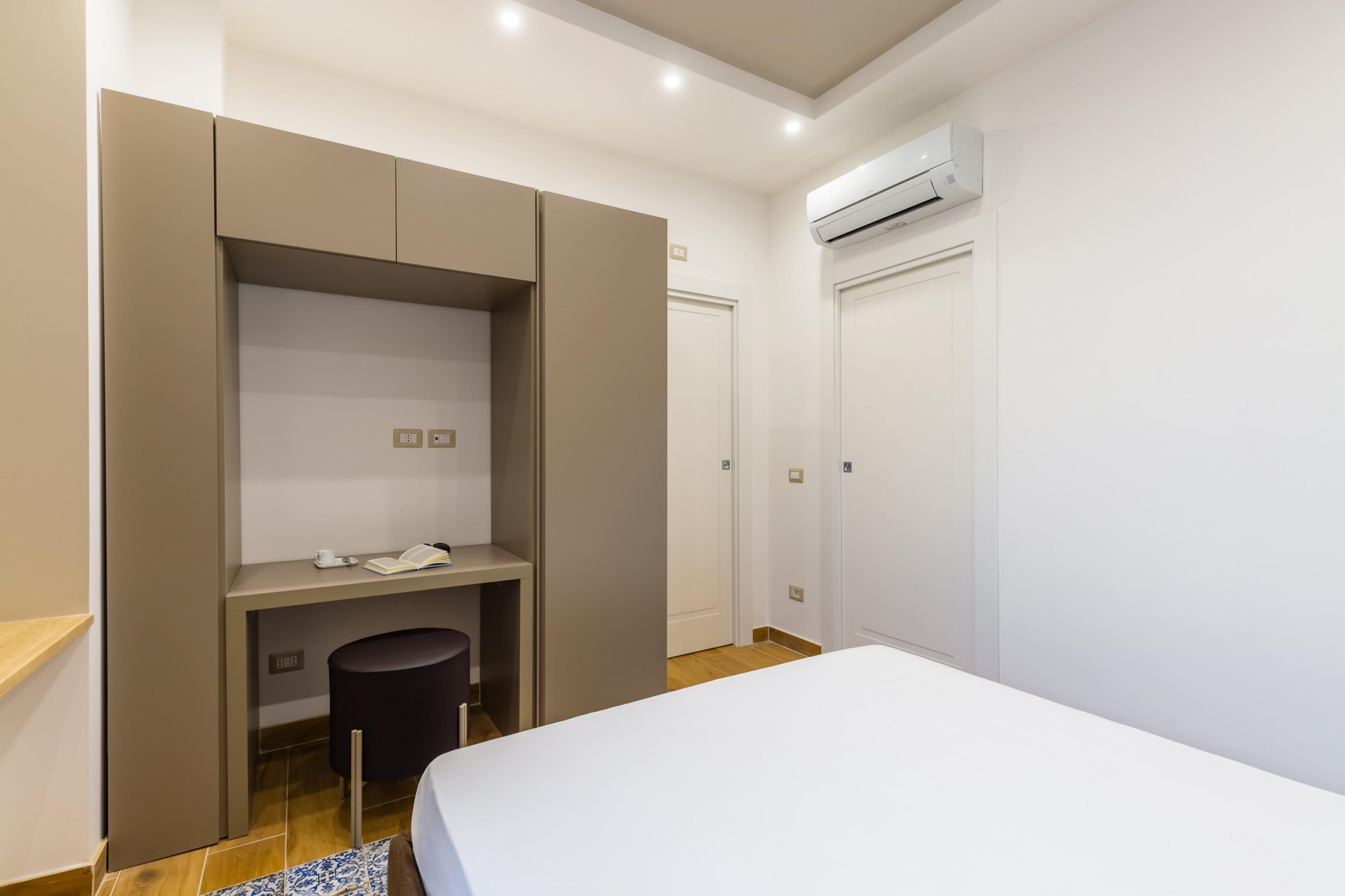 Une chambre à coucher moderne, avec un lit, un bureau et une armoire.