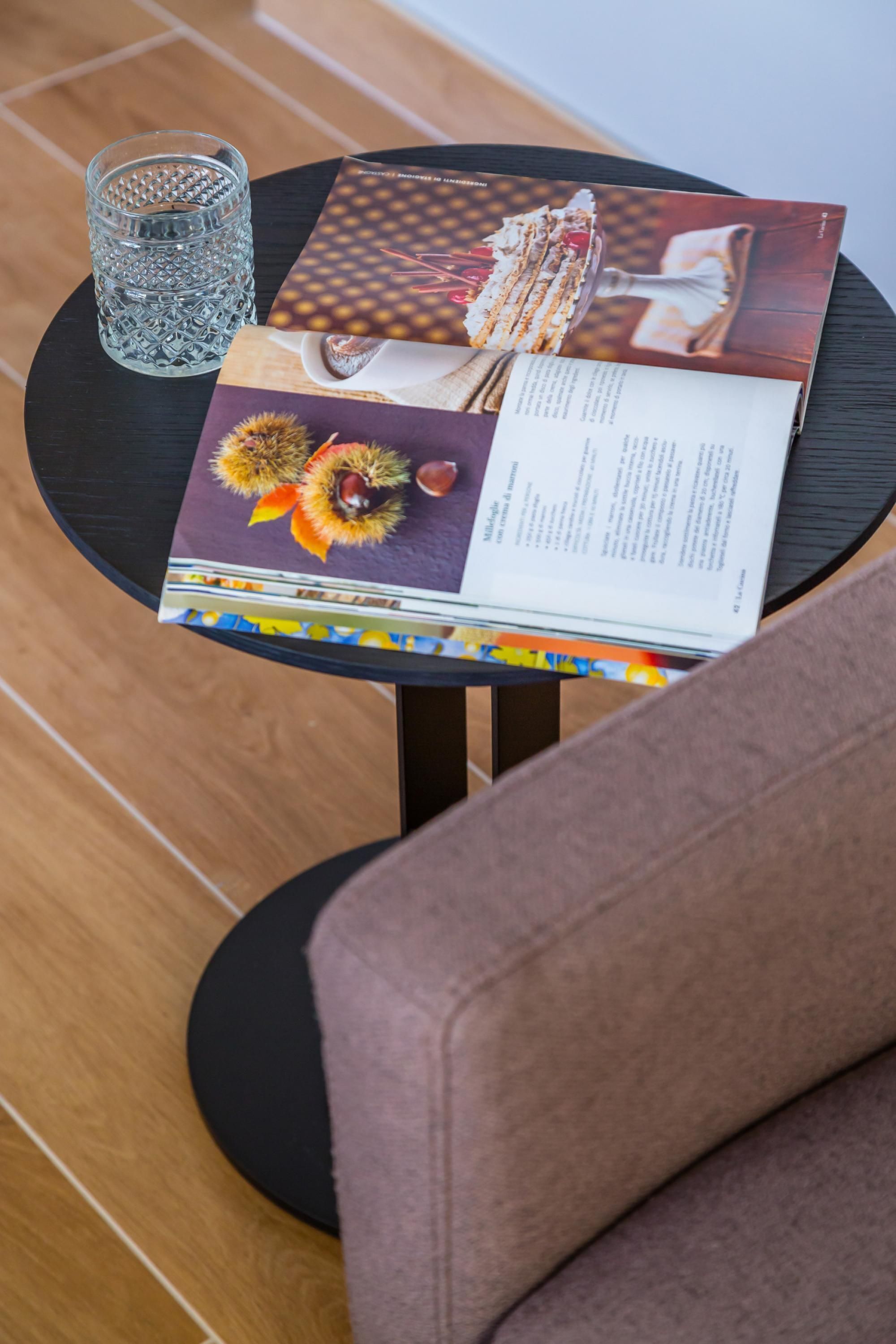 A table with a magazine, a glass, and a decorative item.