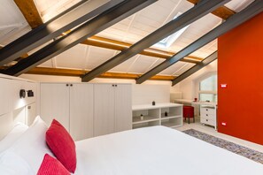 A bedroom with a skylight, a white bed, and red pillows. - Chiaia Elegant Apartment 2 by Wonderful Italy (Naples)