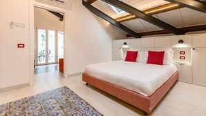 A bedroom with a large bed, a skylight, and a view of the outdoors.