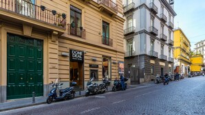 A cobblestone street lined with parked motorcycles and buildings with balconies.