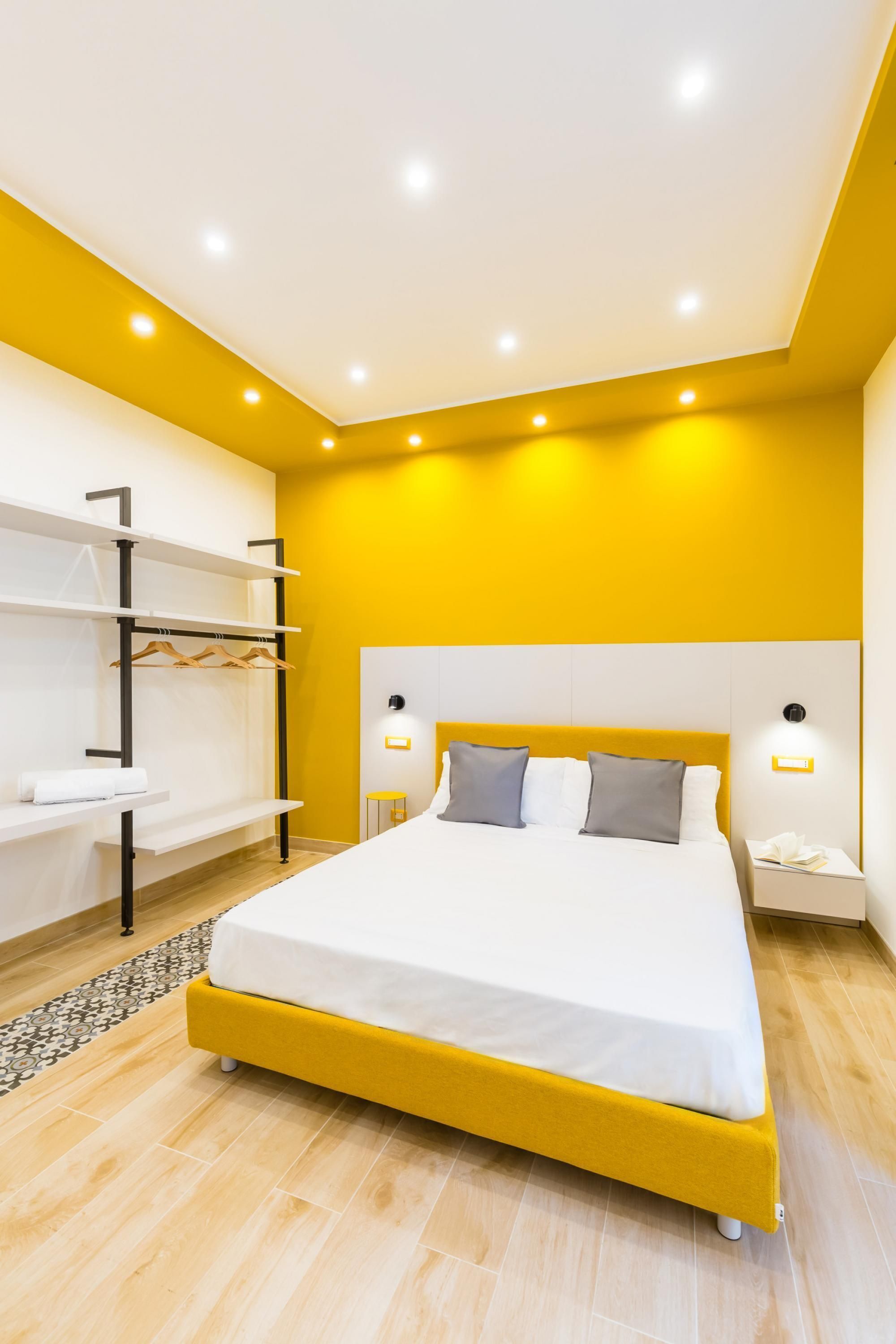 A modern bedroom with a bed, bedside tables, and a built-in wardrobe.