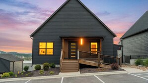 A dark-colored building with a triangular roof, a front door, and a staircase leading up to the entrance. - Your Relaxation Destination at Emerald Shores (Hollister)