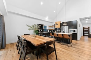 A modern kitchen with a wooden dining table and chairs, a built-in oven, and a large window. - Your Relaxation Destination at Emerald Shores (Hollister)