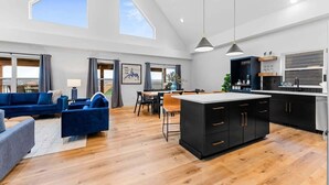 A spacious living area with a sofa, dining table, and kitchen island. - Your Relaxation Destination at Emerald Shores (Hollister)