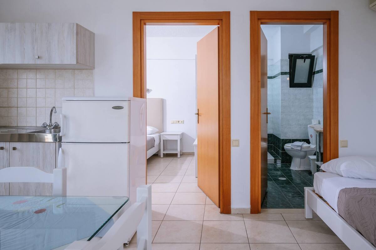 Una habitación de hotel moderna con cocina, baño y dormitorio.