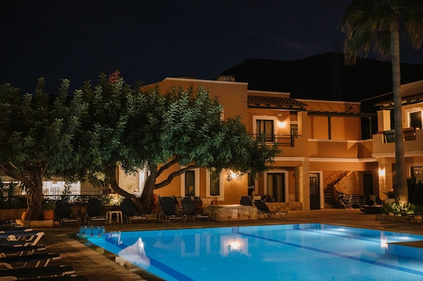 Vista frontal de la propiedad por la tarde o noche