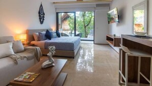 Een moderne slaapkamer met een bed, een bank, een salontafel en een televisie.