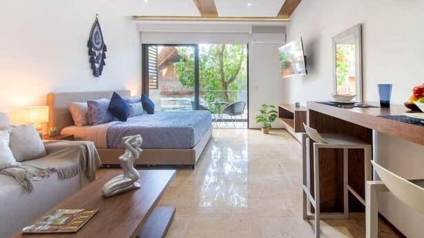 Een moderne slaapkamer met een bed, nachtkastje en uitzicht op de omgeving.