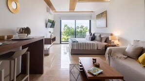 Een moderne woonkamer met een bank, een salontafel en een bed met uitzicht op het omliggende landschap.