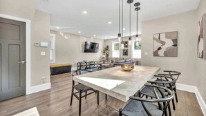 A modern kitchen with a large island, pendant lighting, and a flat-screen TV. - 2 King Beds | Sauna, Hot Tub & Pickleball Court (Cleveland)