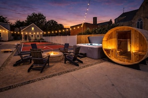 A cozy outdoor patio with a fire pit, seating, and a hot tub. - 2 King Beds, Sauna, Hot Tub & Pickleball Court (Cleveland)