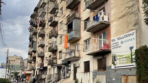 A multi-story building with balconies, a signboard, and a paved pathway. - Shartava 1 (Kutaisi)