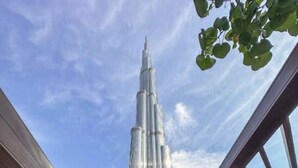 A pool area with lounge chairs and a view of the Burj Khalifa. - EDEN'S Homes & Villas - Address Opera District Residences (Dubai)