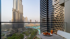 A balcony with a table, a plate of croissants, and a glass of orange juice. - EDEN'S Homes & Villas - Address Opera District Residences (Dubai)
