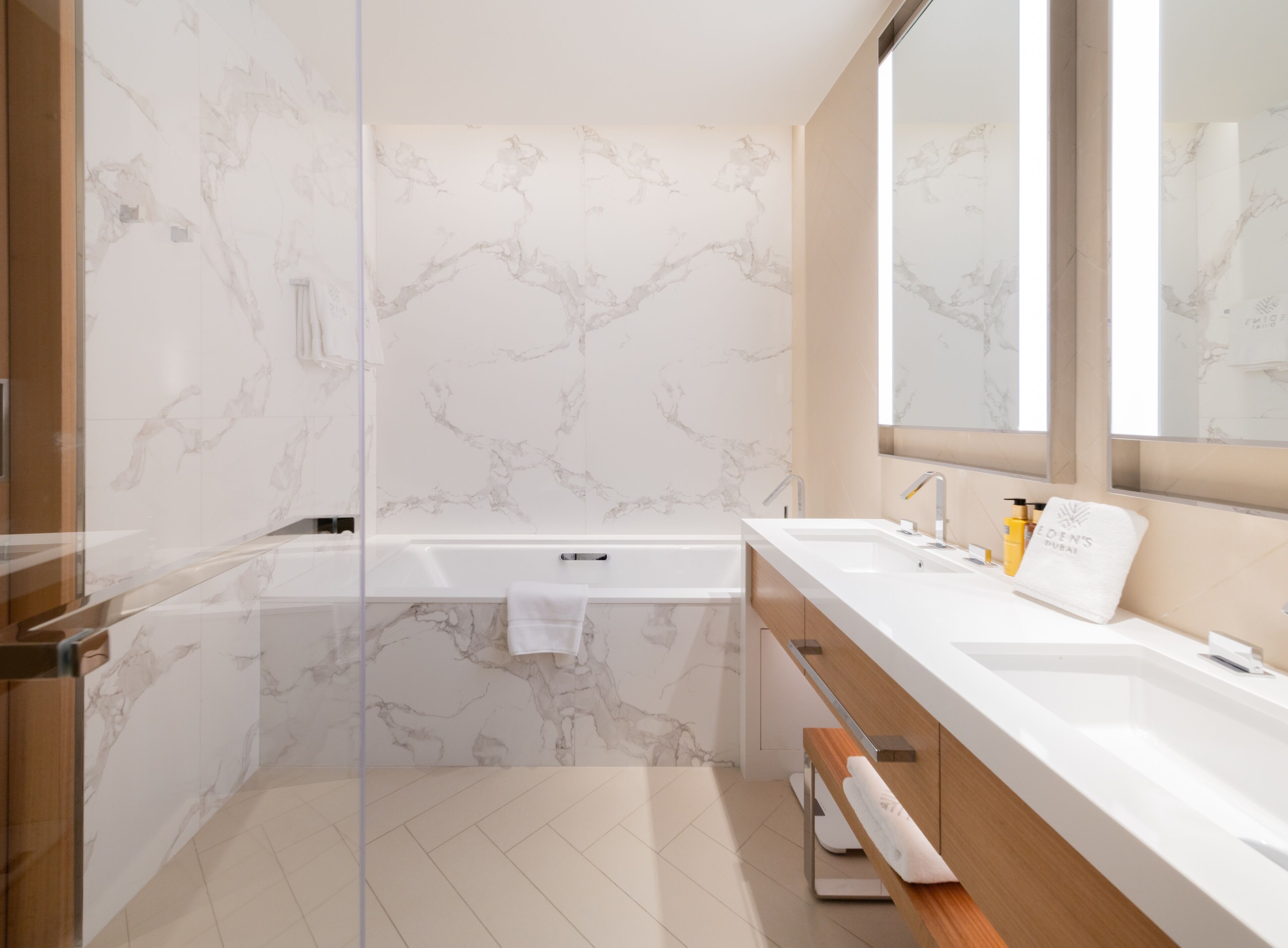 Une salle de bain moderne dotée d’une douche à parois de verre, d’une baignoire et d’un meuble-lavabo avec un évier et un miroir.