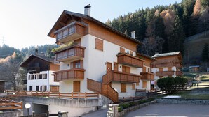 Un chalet à plusieurs étages, doté de balcons en bois et d’une façade en pierre.